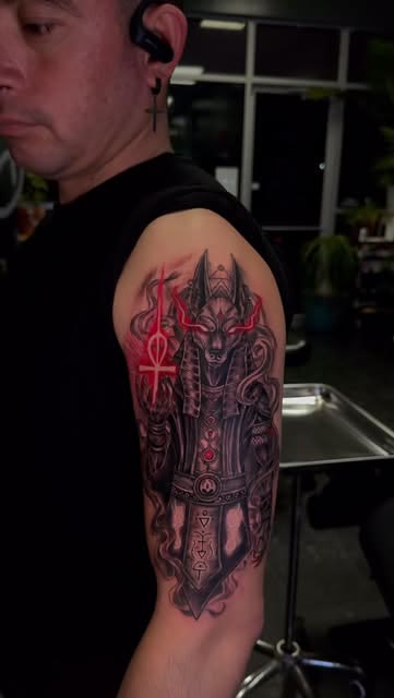 Anubis, red and black tattoo by Carlos Tattoo in Tallahassee